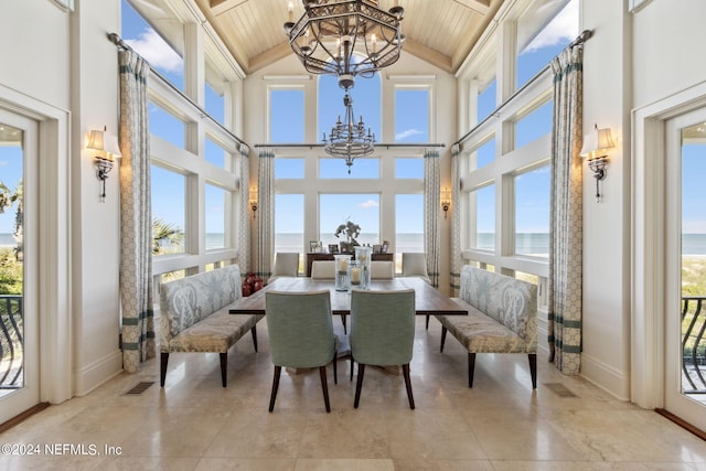 sunroom featuring wood ceiling, a water view, and a healthy amount of sunlight