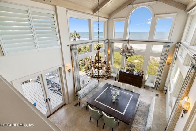 sunroom featuring an inviting chandelier, lofted ceiling with beams, a water view, and wooden ceiling