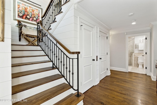 stairway with wood-type flooring and crown molding