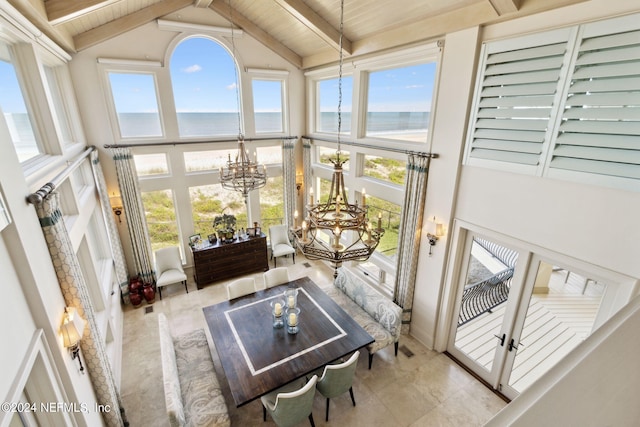 sunroom featuring vaulted ceiling with beams, wooden ceiling, a water view, and a healthy amount of sunlight