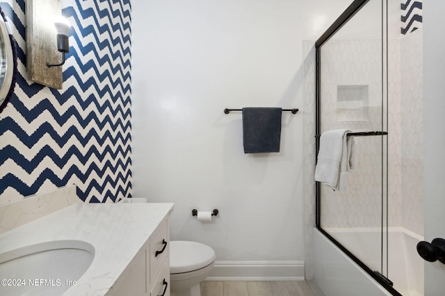 full bathroom featuring shower / bath combination with glass door, vanity, and toilet