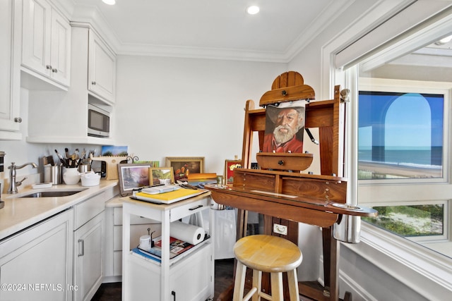 901 Ponte Vedra Blvd, Ponte Vedra Beach, FL 32082 - kitchen with stainless steel microwave, light countertops, a sink, white cabinetry, and crown molding