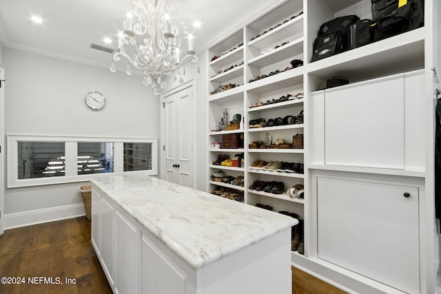 spacious closet featuring dark hardwood / wood-style flooring and a notable chandelier