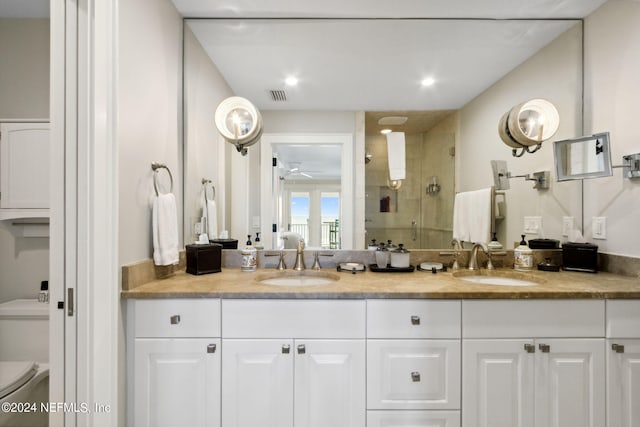 bathroom featuring walk in shower, vanity, toilet, and ceiling fan