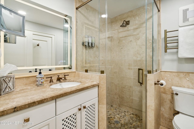 bathroom featuring vanity, toilet, and a shower with door