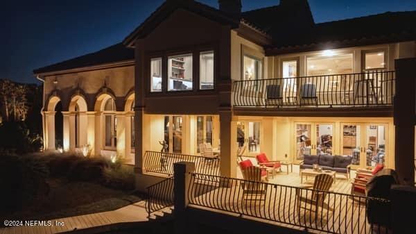 901 Ponte Vedra Blvd, Ponte Vedra Beach, FL 32082 - back of house at twilight featuring an outdoor hangout area, a patio, a chimney, and a balcony