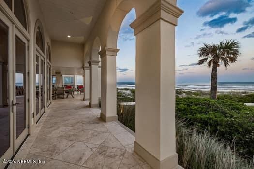 exterior space with a water view, a beach view, and a patio area