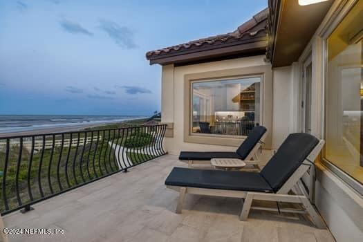 balcony featuring a water view and a view of the beach