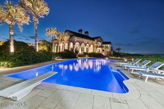 view of swimming pool featuring a diving board and a patio area