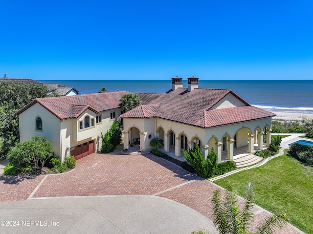 mediterranean / spanish-style home featuring a water view, a beach view, and a front yard