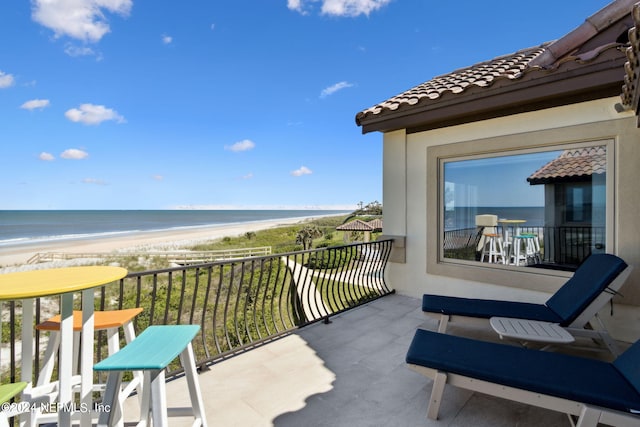 balcony with a water view and a beach view