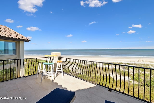 balcony with a water view and a beach view