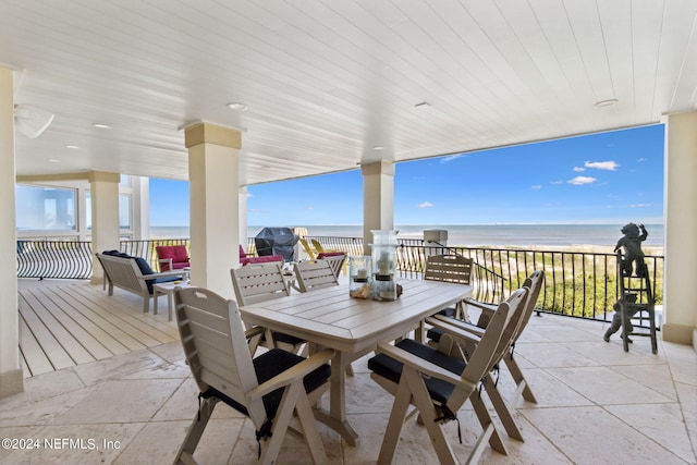 view of patio / terrace featuring a water view and a beach view