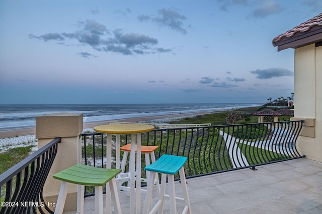 balcony featuring a water view and a view of the beach