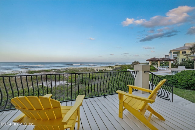 balcony featuring a water view and a beach view