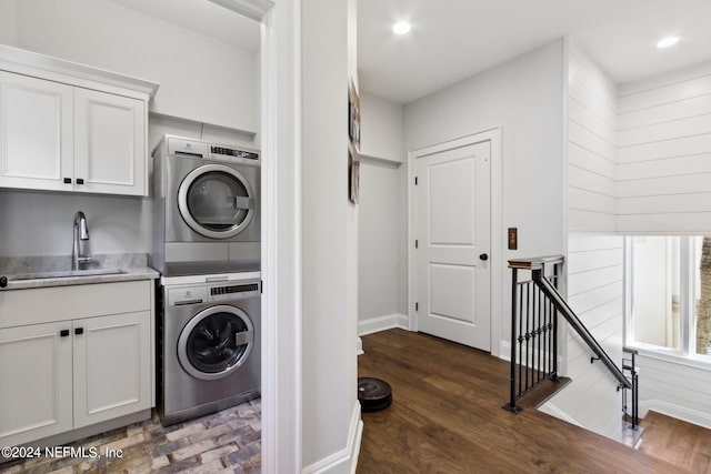 laundry area with stacked washing maching and dryer, sink, and dark hardwood / wood-style flooring