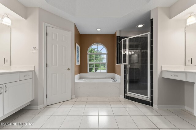 bathroom featuring independent shower and bath, vanity, and tile patterned floors