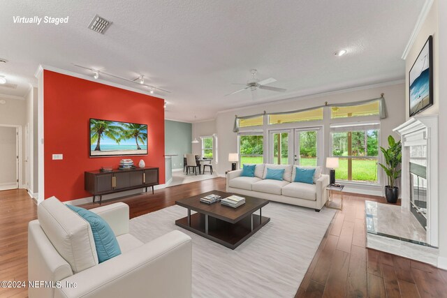 living room featuring ceiling fan, hardwood / wood-style flooring, french doors, and crown molding