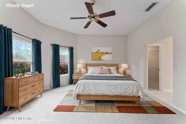 bedroom featuring multiple windows, a spacious closet, and light colored carpet