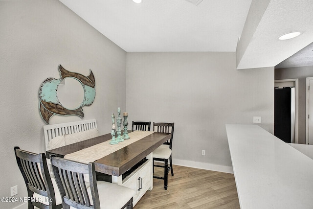 dining area with baseboards, wood finished floors, and recessed lighting