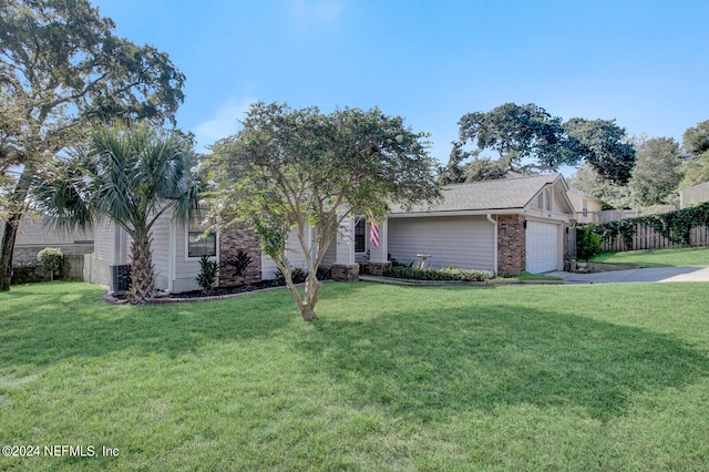 view of front of property featuring a front yard, a garage, and cooling unit