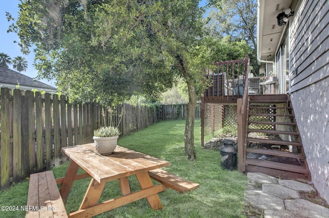 view of yard with stairs, a deck, and a fenced backyard