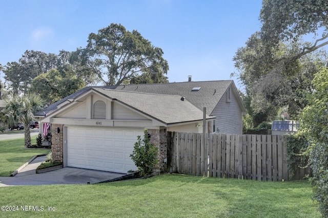 exterior space with a yard, brick siding, fence, and an attached garage