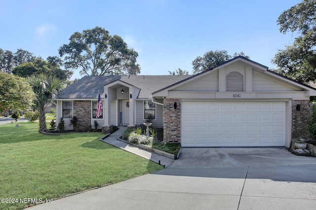 ranch-style home featuring a garage, a front yard, concrete driveway, and brick siding