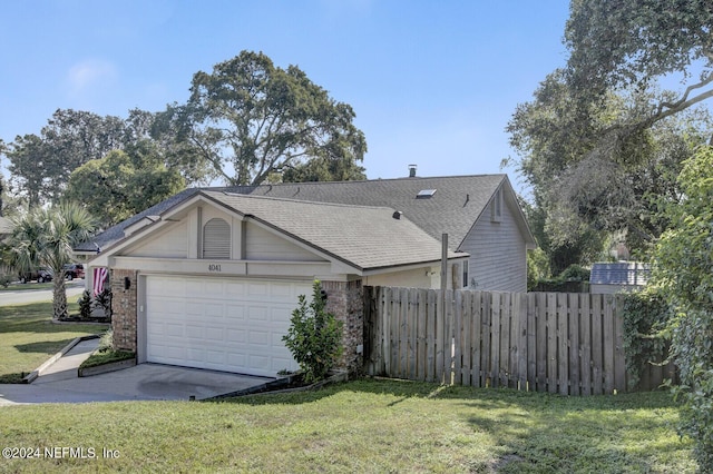 exterior space with brick siding, a yard, a shingled roof, fence, and a garage