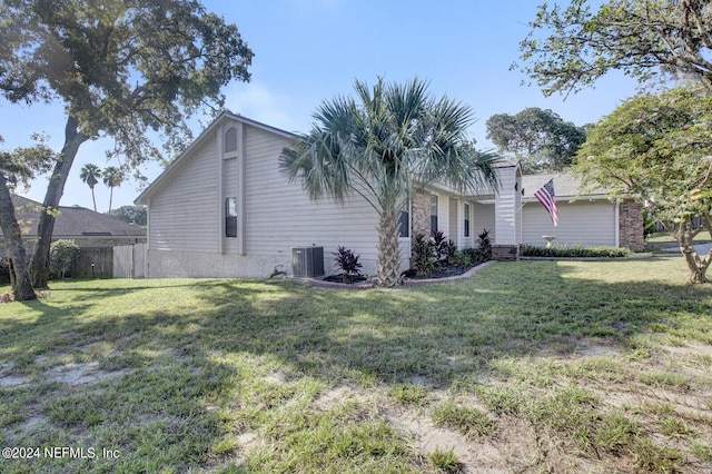 view of home's exterior with a yard, cooling unit, and fence