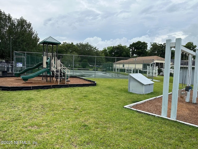 community jungle gym featuring fence and a lawn