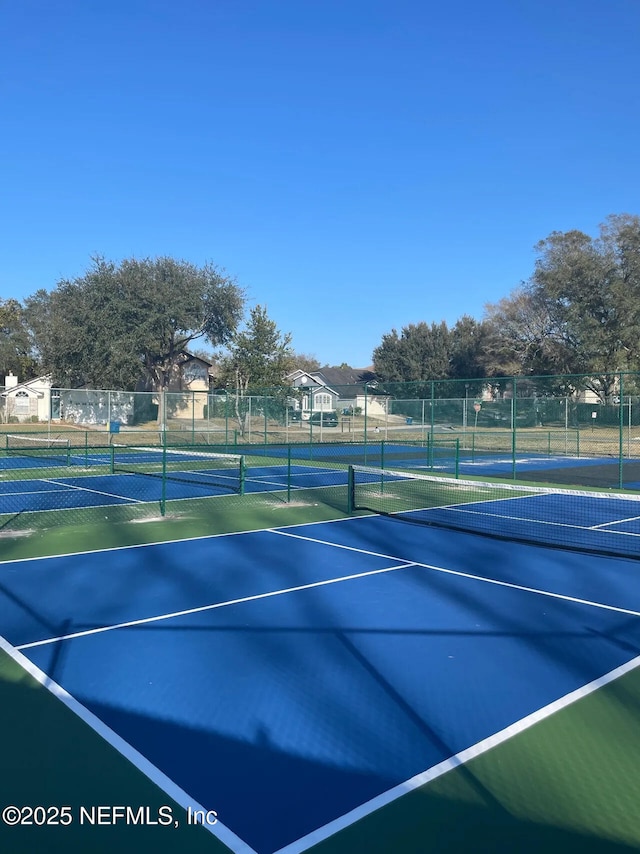 view of tennis court featuring fence