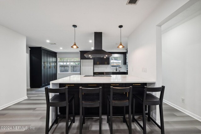 kitchen featuring island range hood, a healthy amount of sunlight, kitchen peninsula, and decorative light fixtures