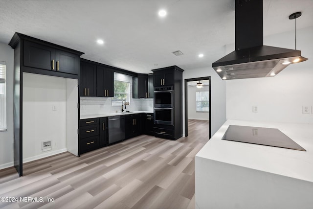 kitchen with appliances with stainless steel finishes, light hardwood / wood-style floors, island range hood, hanging light fixtures, and sink