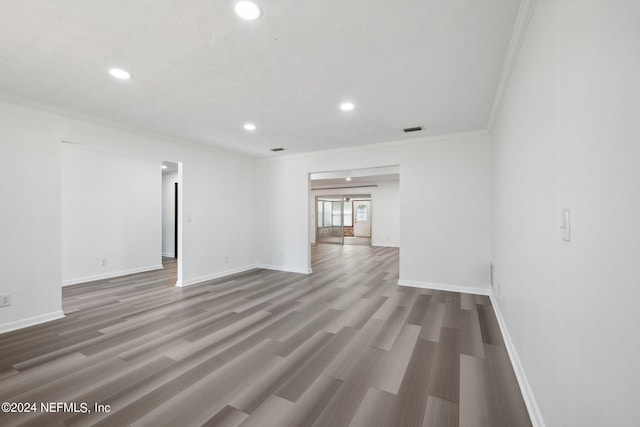 spare room with ornamental molding and wood-type flooring