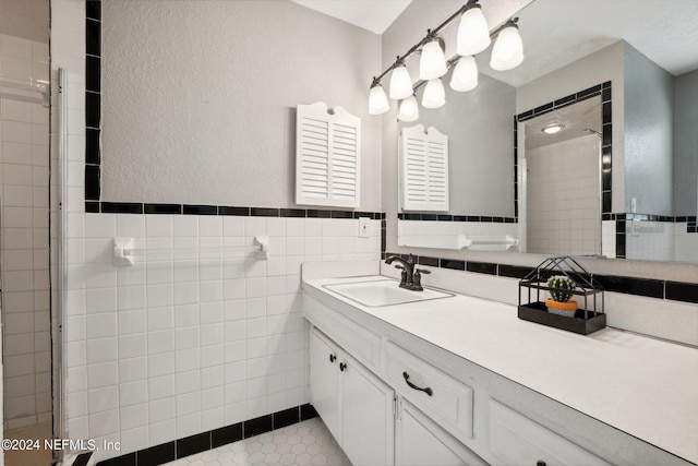 bathroom with vanity, a shower with shower door, tile patterned flooring, tile walls, and decorative backsplash