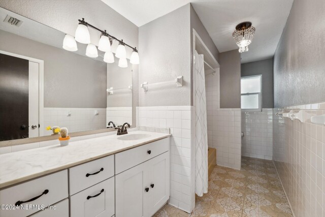 bathroom featuring vanity, tile walls, tile patterned flooring, and shower with separate bathtub