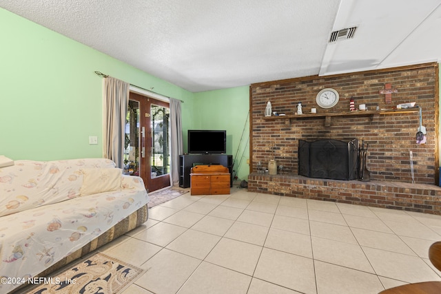 living room featuring a textured ceiling, a fireplace, light tile patterned floors, and french doors