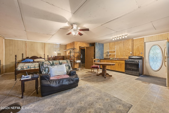 living room with wood walls, sink, and ceiling fan