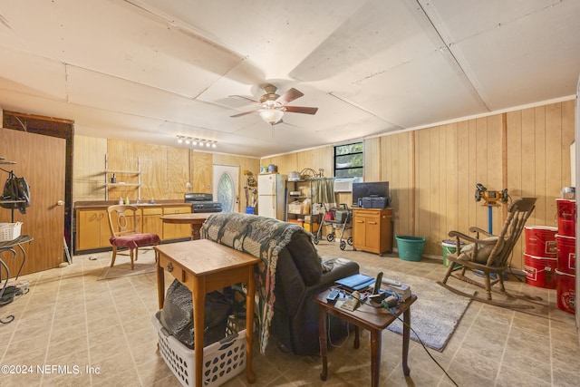 living room featuring ceiling fan and wood walls