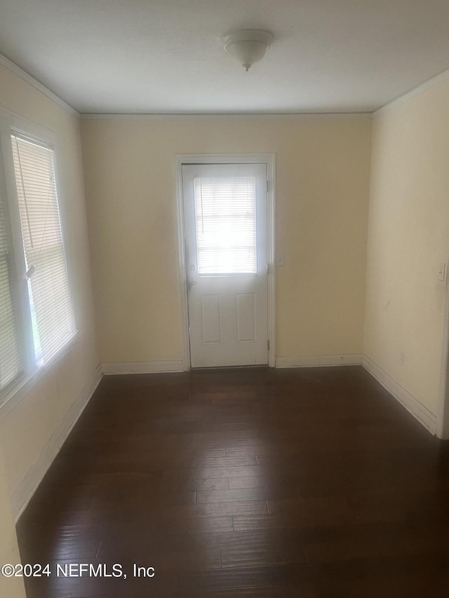 spare room featuring dark wood-style floors and baseboards