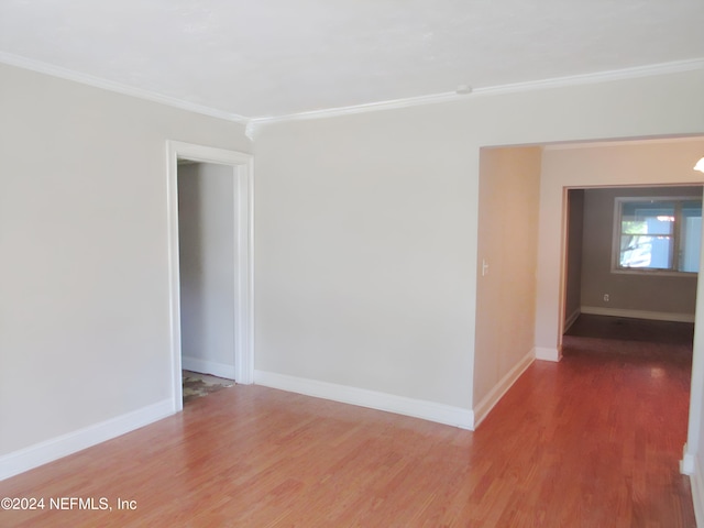 empty room with ornamental molding and wood-type flooring