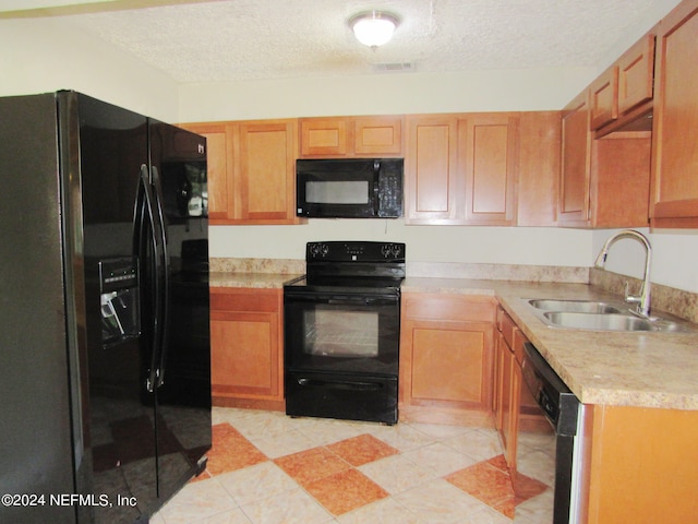 kitchen featuring black appliances, a textured ceiling, and sink