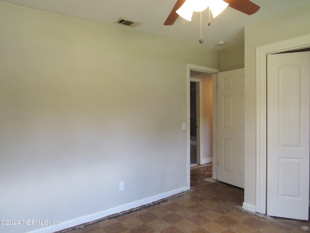 unfurnished bedroom with ceiling fan and a closet