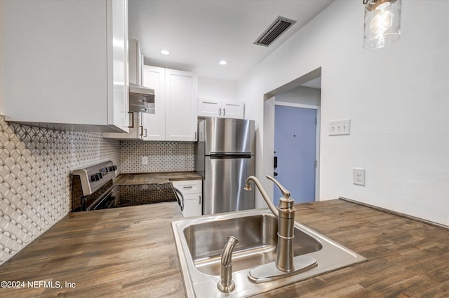 kitchen with backsplash, appliances with stainless steel finishes, sink, hardwood / wood-style flooring, and white cabinets