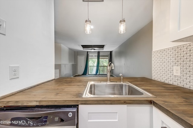 kitchen featuring dishwasher, hanging light fixtures, sink, wooden counters, and white cabinets