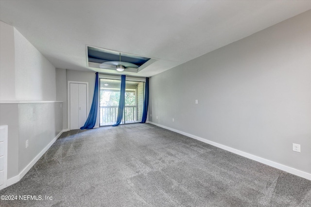 unfurnished room featuring a tray ceiling and carpet floors