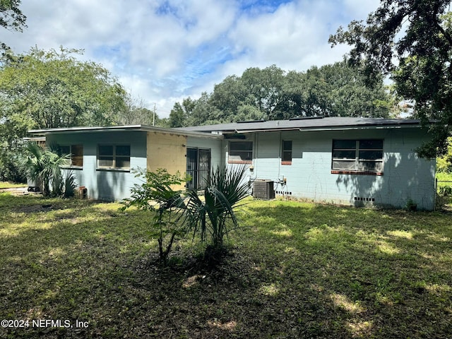 rear view of house with a yard and central AC unit