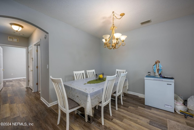 dining room featuring arched walkways, visible vents, and wood finished floors
