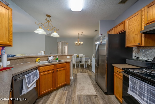 kitchen with wood finished floors, tasteful backsplash, arched walkways, appliances with stainless steel finishes, and a sink